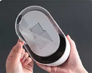 Peeling the protective film off the adhesive pad on the back of the unit